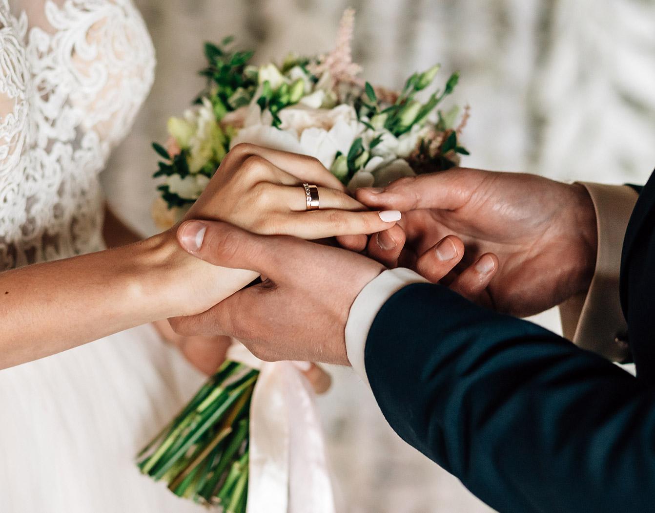 Man putting wedding ring on woman