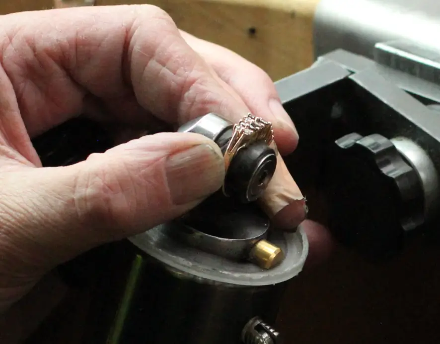 Close up of a diamond ring with its diamond about to be reset
